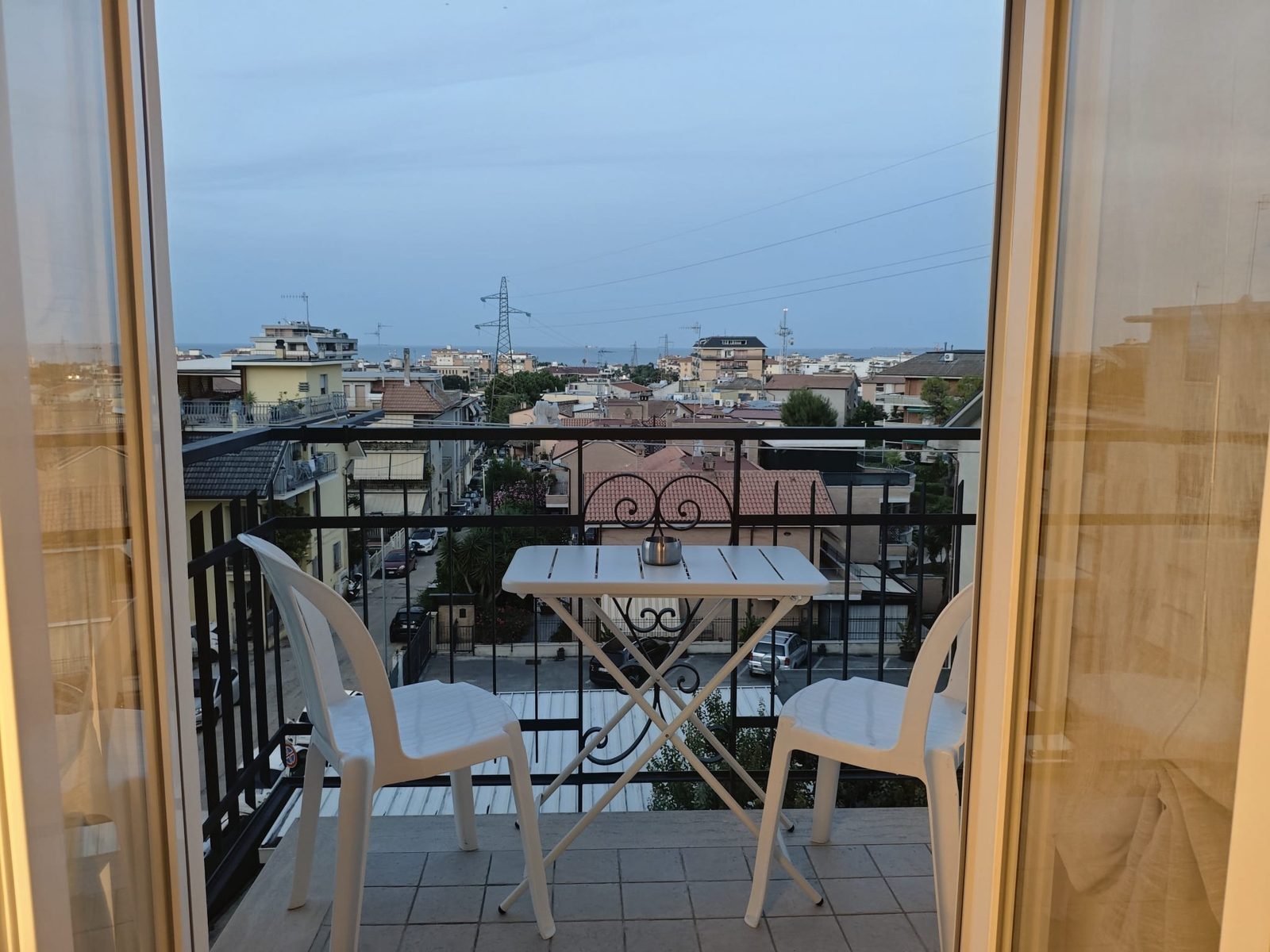 Balcone con tavolo e sedie e vista sul mare