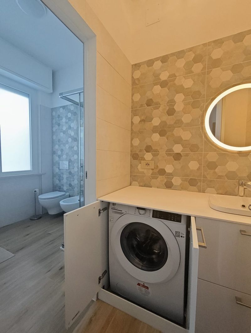 Bagno con doccia, sanitari e lavatrice a scomparsa