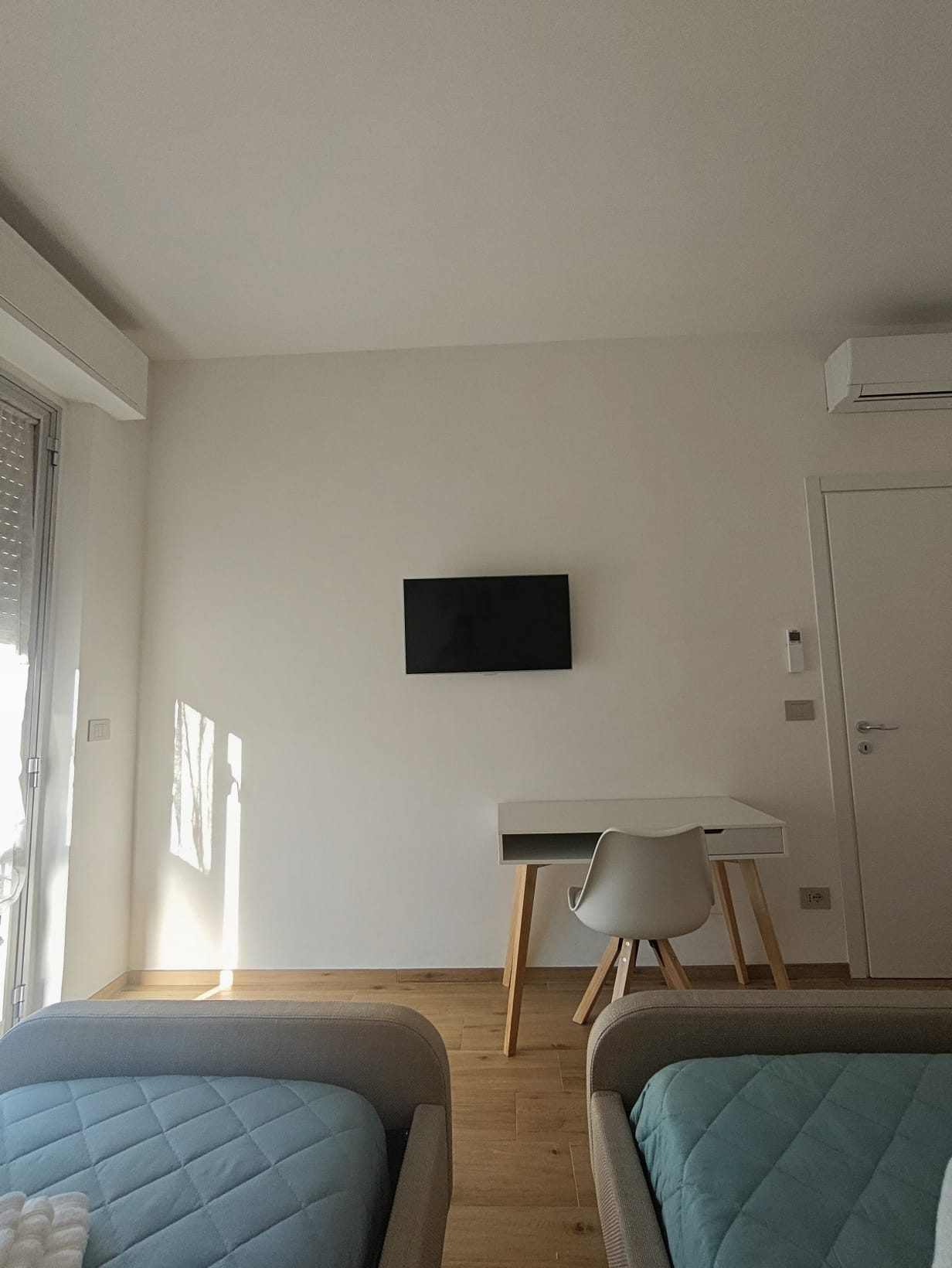 Seconda camera con due letti singoli, scrivania e TV